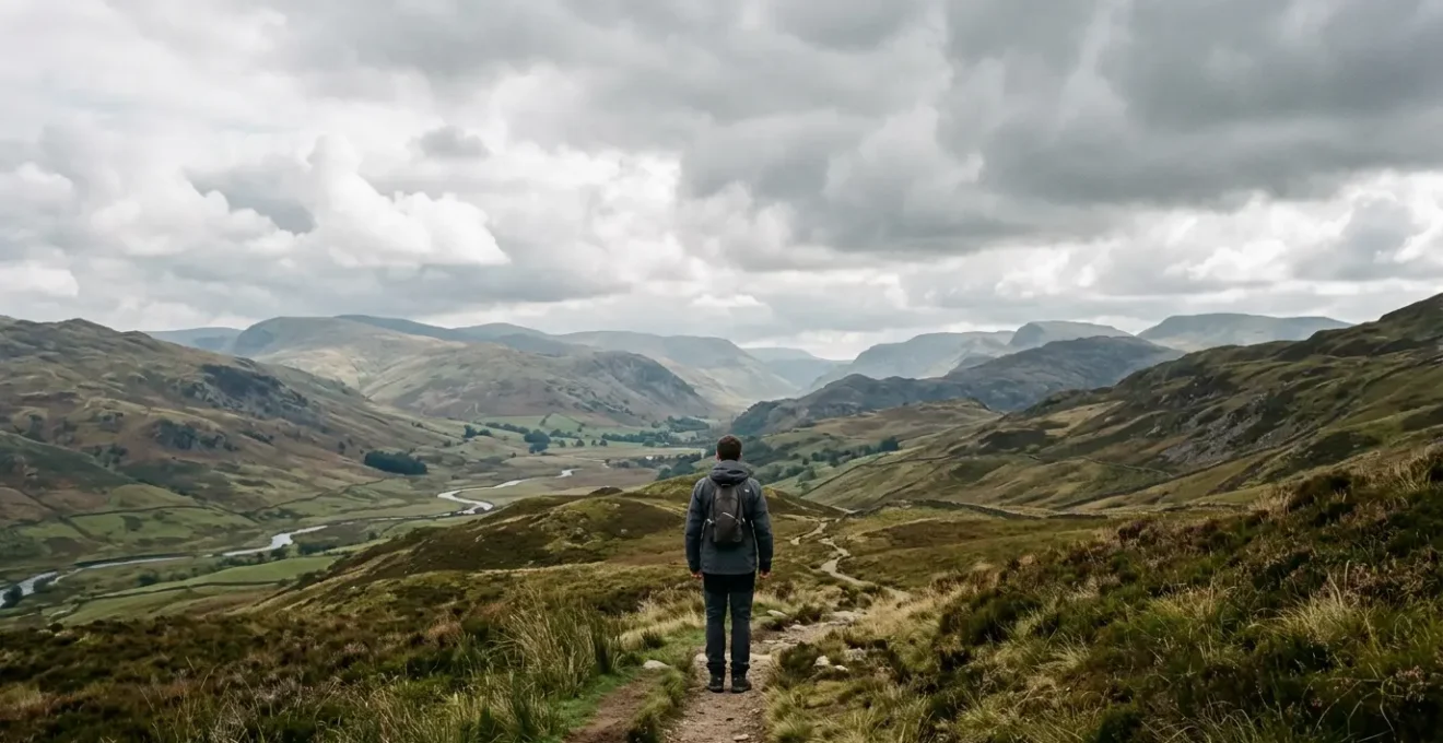 A solitary figure standing at a distance on an overcast British landscape with negative space emphasizing isolation